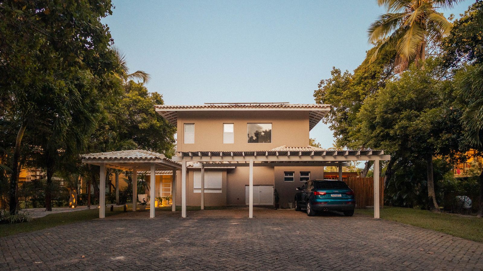 Two-storey tropical home surrounded by palms